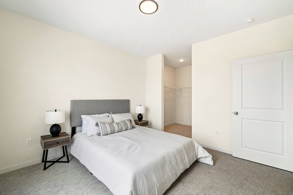 a bedroom with a large bed and a closet a bedroom with a large bed and a closet at The Standard on 32nd, West Fargo