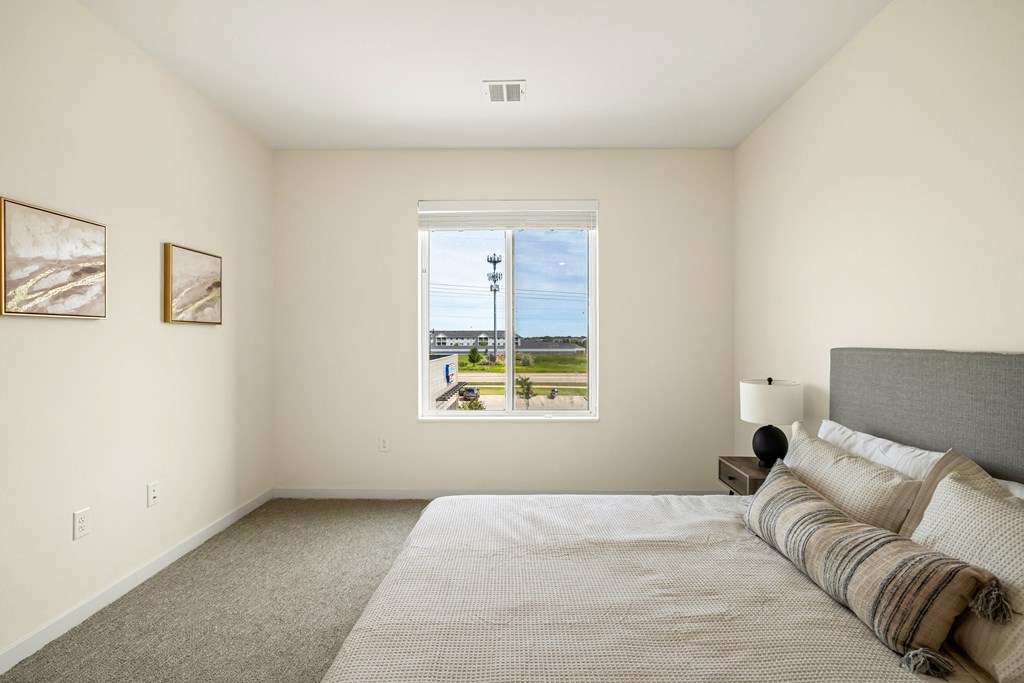 a bedroom with a large bed and a window at The Standard on 32nd, West Fargo, North Dakota