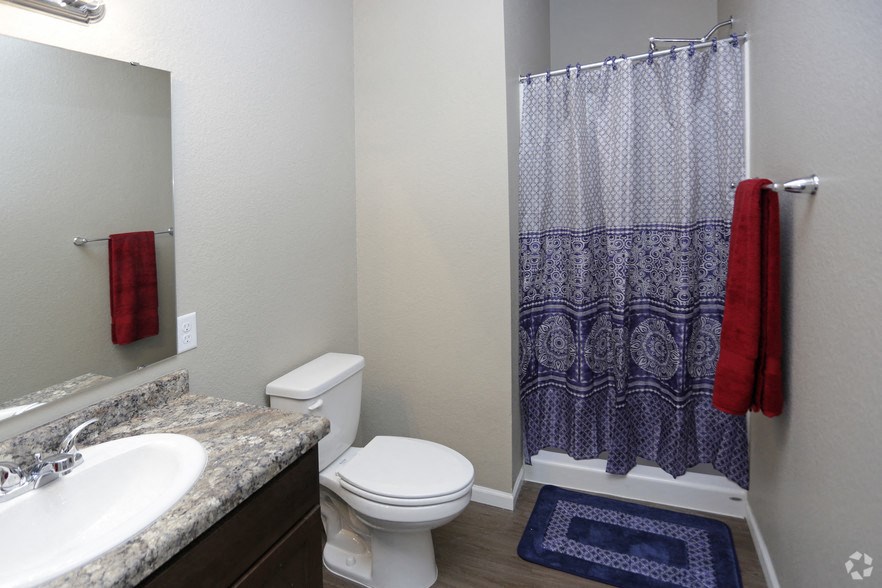 a bathroom with a toilet and a sink and a shower