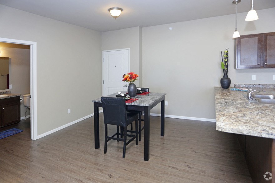 a dining room with a table and chairs and a kitchen with a sink