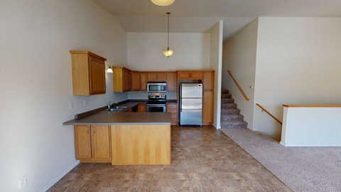 A kitchen with wooden cabinets and a tiled floor.