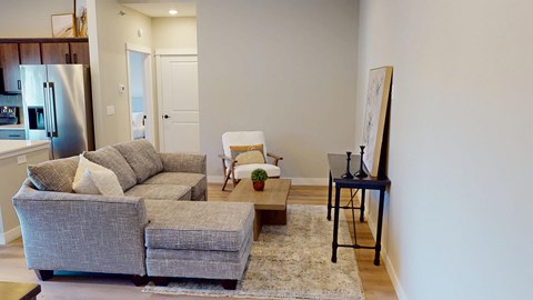 A living room with a grey couch and a small table.
