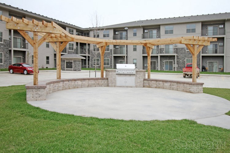 an outdoor patio with a fire pit in front of an apartment building