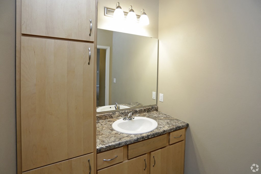 A bathroom with a sink and a mirror.
