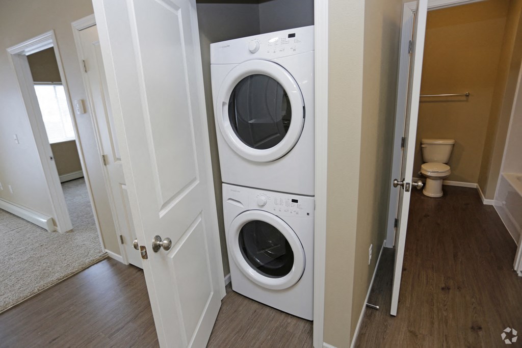 A white washer and dryer are in a small laundry room.