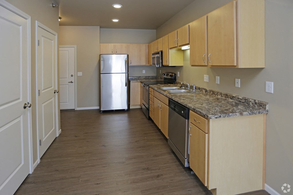 A kitchen with wooden cabinets and granite countertops.
