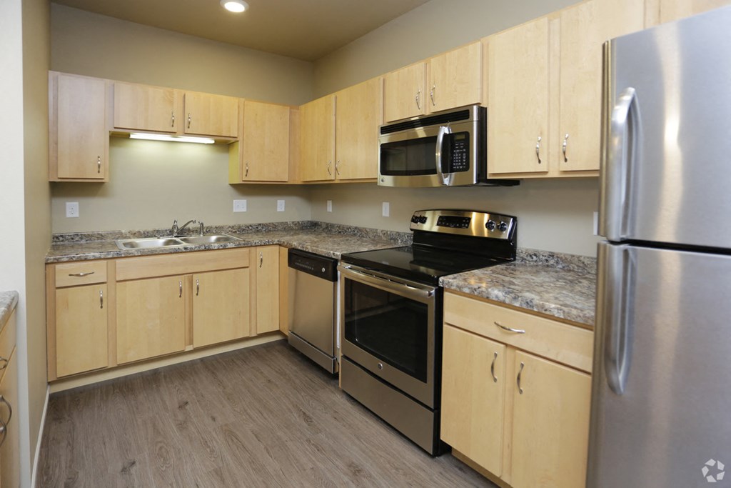 A kitchen with wooden cabinets and stainless steel appliances.