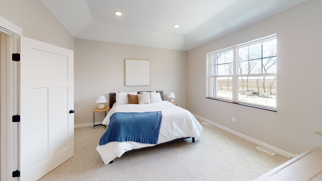 A bedroom with a bed, pillows, and a blanket.