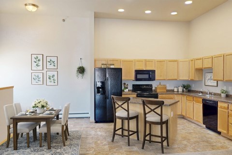 A kitchen with a table and chairs in the middle of the room.