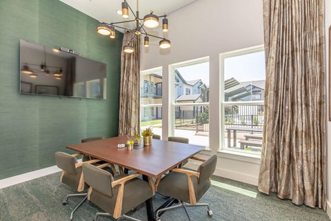 A conference room with a long table and chairs.