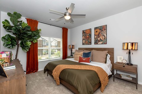 A bedroom with two beds and a ceiling fan.