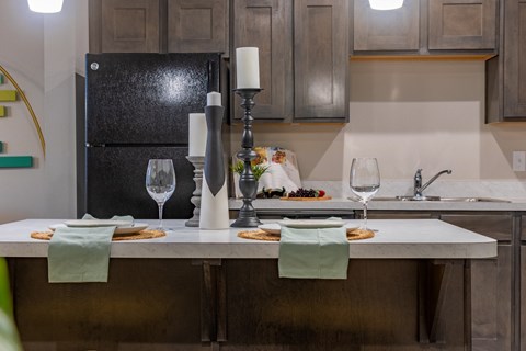 a kitchen with a marble counter top with plates of food and wine glasses on it