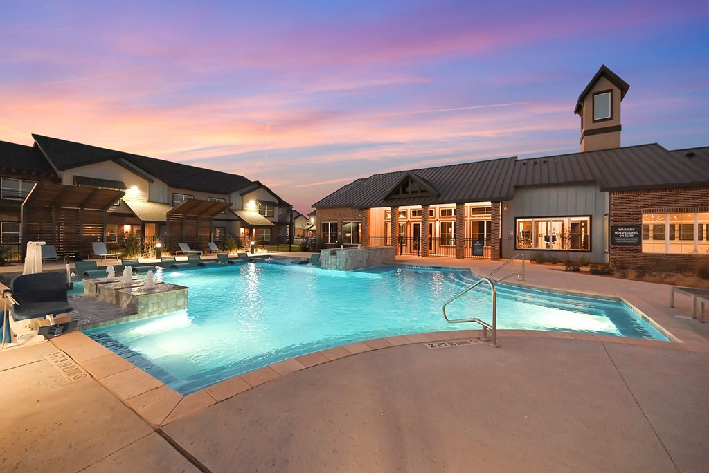 a swimming pool at dusk in front of a building
