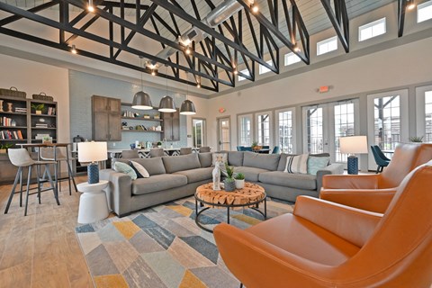 A living room with a grey couch and orange chairs.