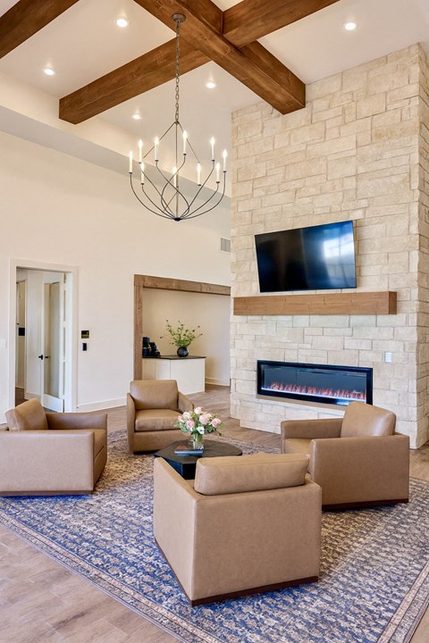 A living room with a fireplace and a television mounted above it.
