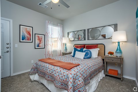 A bedroom with a bed, nightstand, and a ceiling fan.