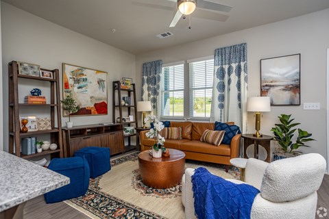 A living room with a brown sofa, a white armchair, and a coffee table.
