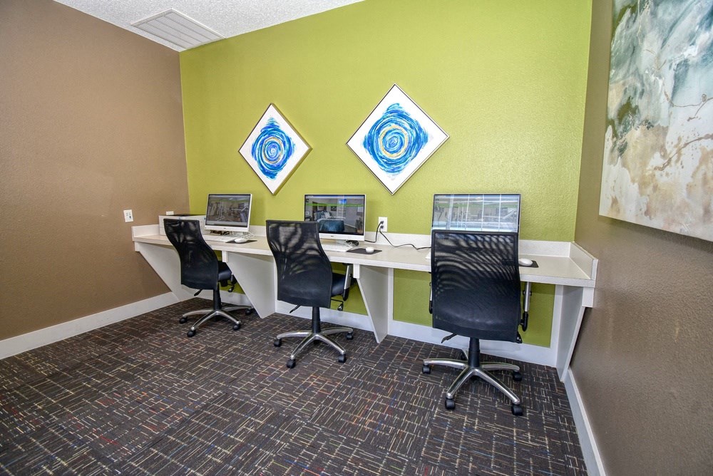 a conference room with two desks and three computer monitors