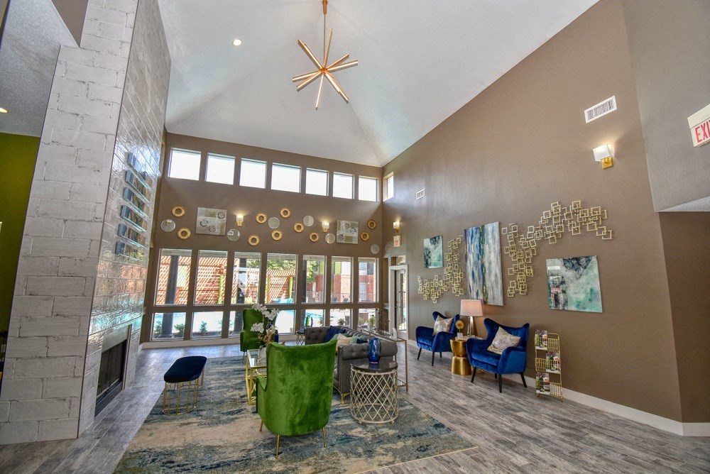 the view of a living room with a fireplace and large windows