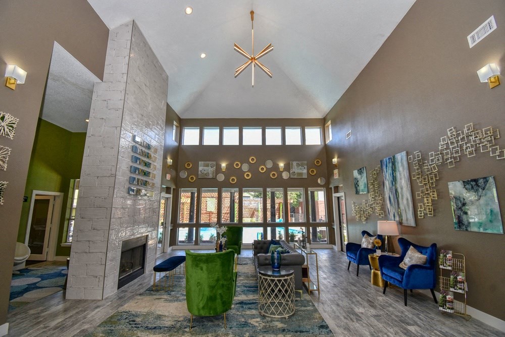 the view of a living room with a fireplace and large windows