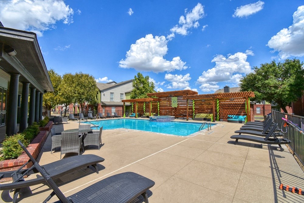 a swimming pool with lounge chairs and a fence around it