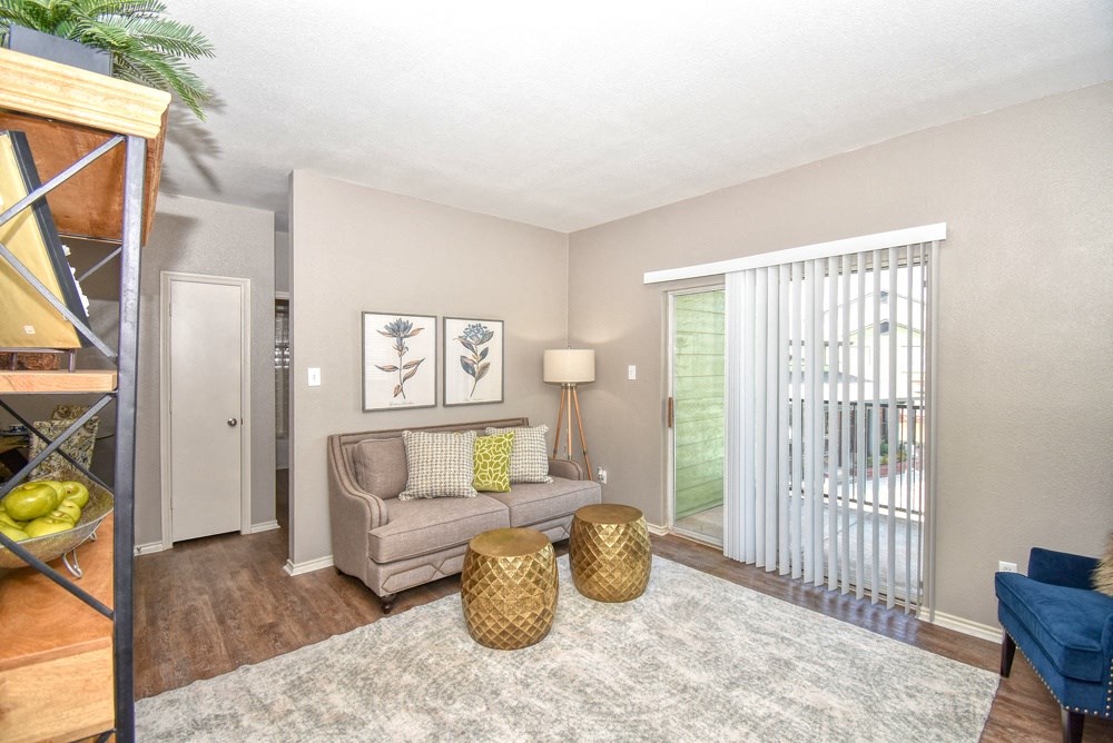 a living room with a couch and a door to a balcony