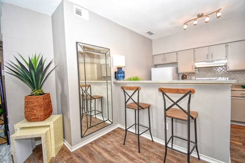 a bar area with stools and a mirror in a living room