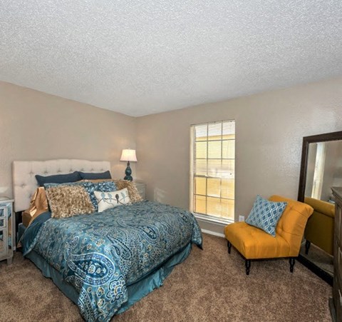 a bedroom with a bed and a yellow chair