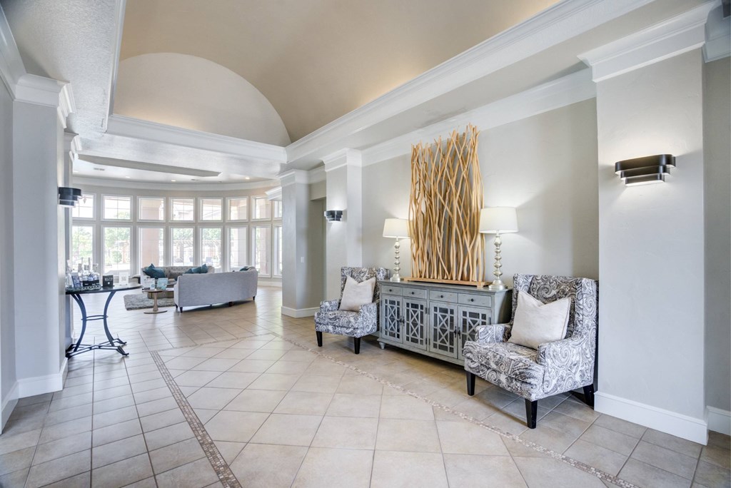 A living room with a grey sofa and a large window.