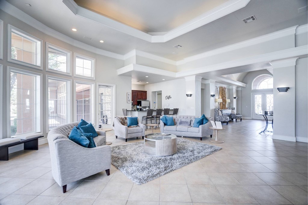 A spacious living room with a grey sofa and a white coffee table.