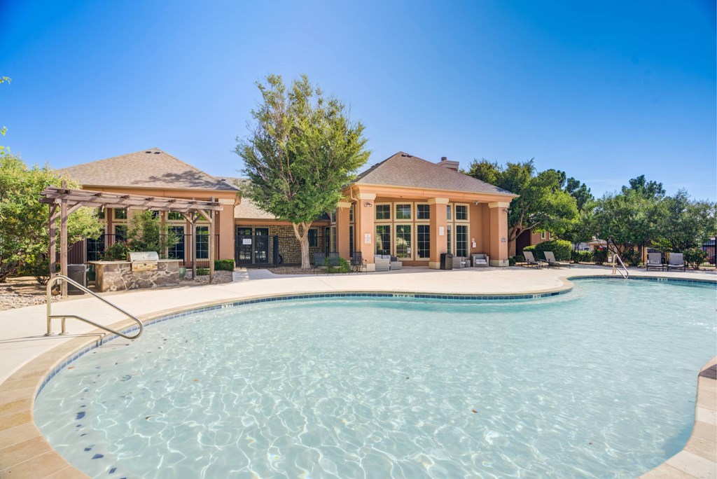 A large swimming pool in front of a house.