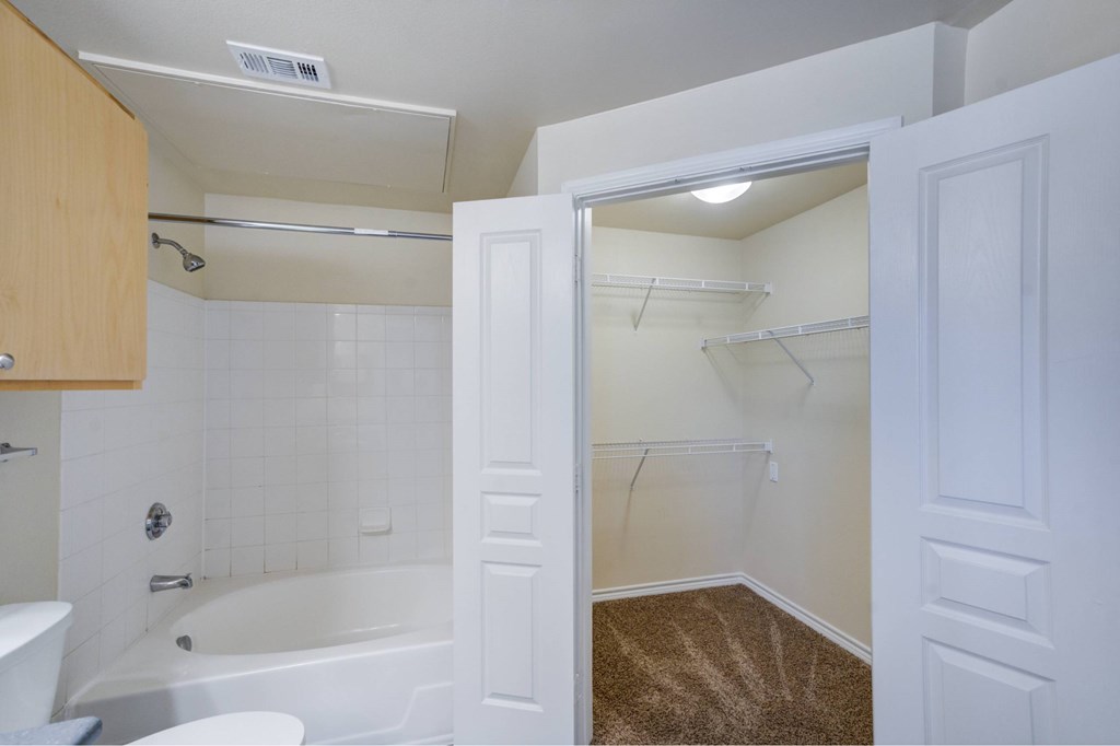 A white bathroom with a tub, toilet, and sink.