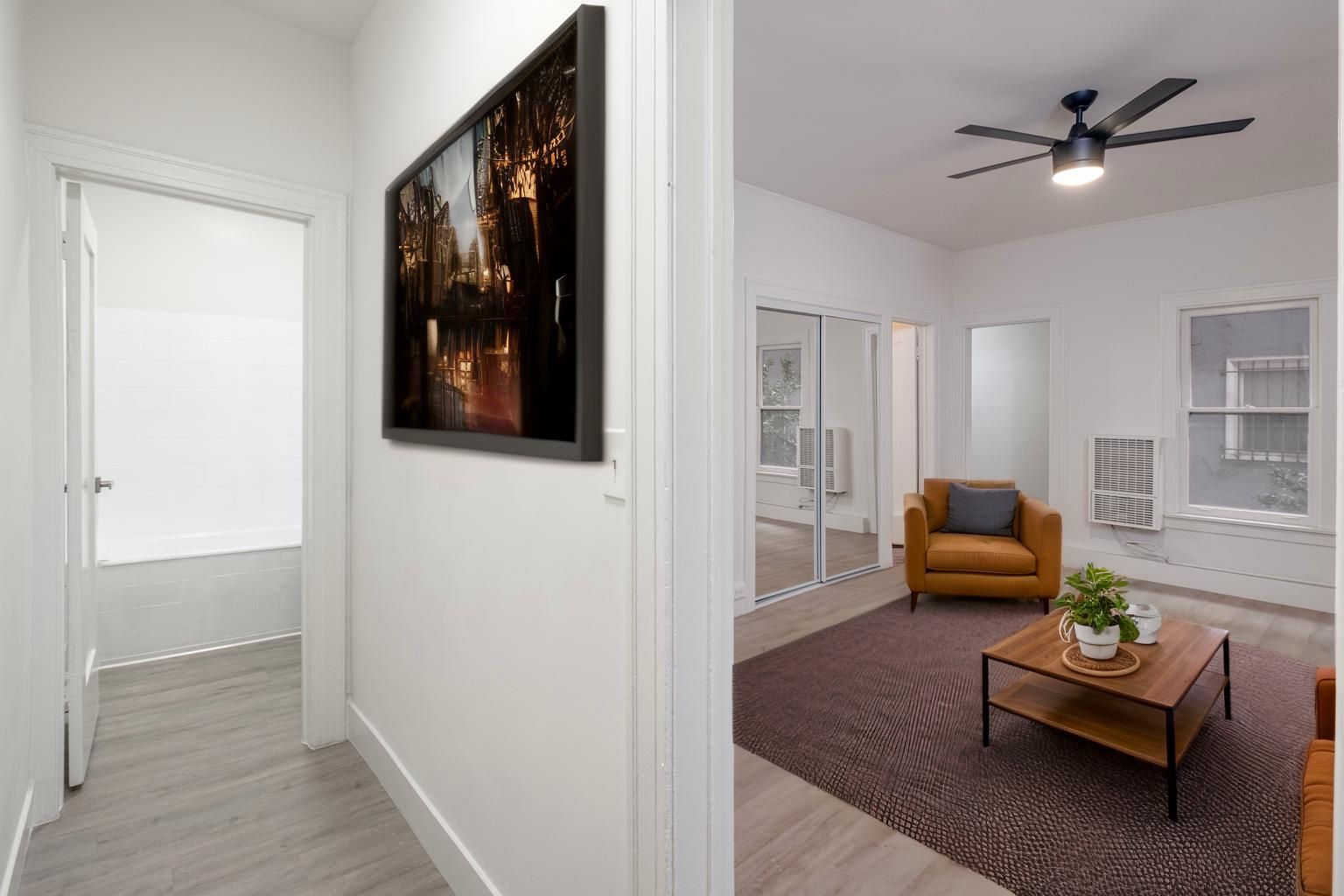 A living room with a brown armchair, a coffee table, and a painting on the wall.