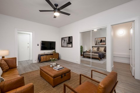 A living room with a brown leather chair and a brown ottoman at Westmore Manor Apartments, Los Angeles, CA, 90020