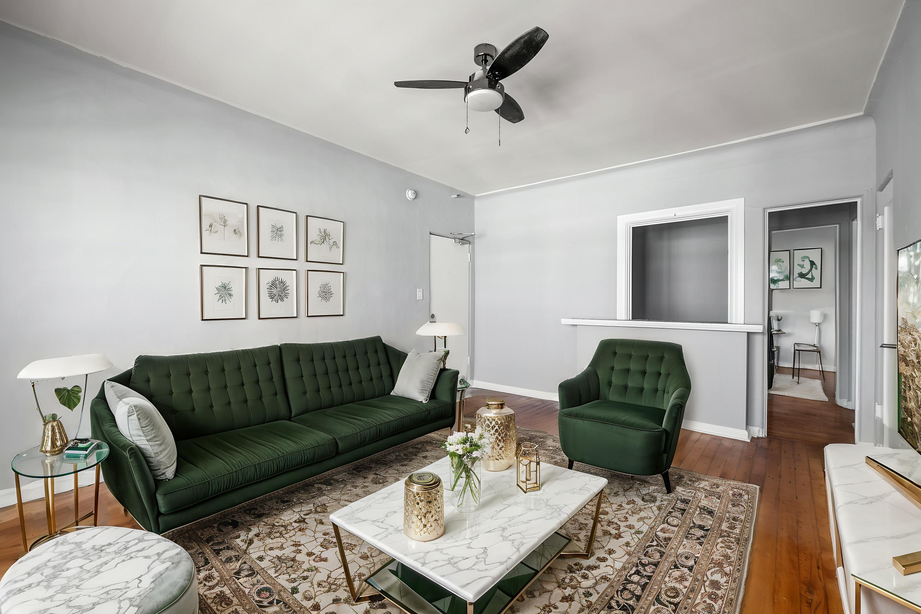 A living room with a green couch and a white coffee table.