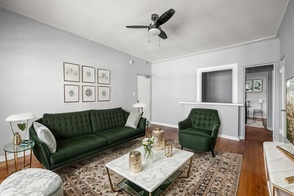 A living room with a green couch and a white coffee table.at Normandie Summit Apartments, California 90004