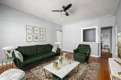 A living room with a green couch and a white coffee table.at Normandie Summit Apartments, California 90004