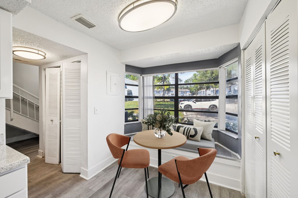 A dining area with a round table and chairs.