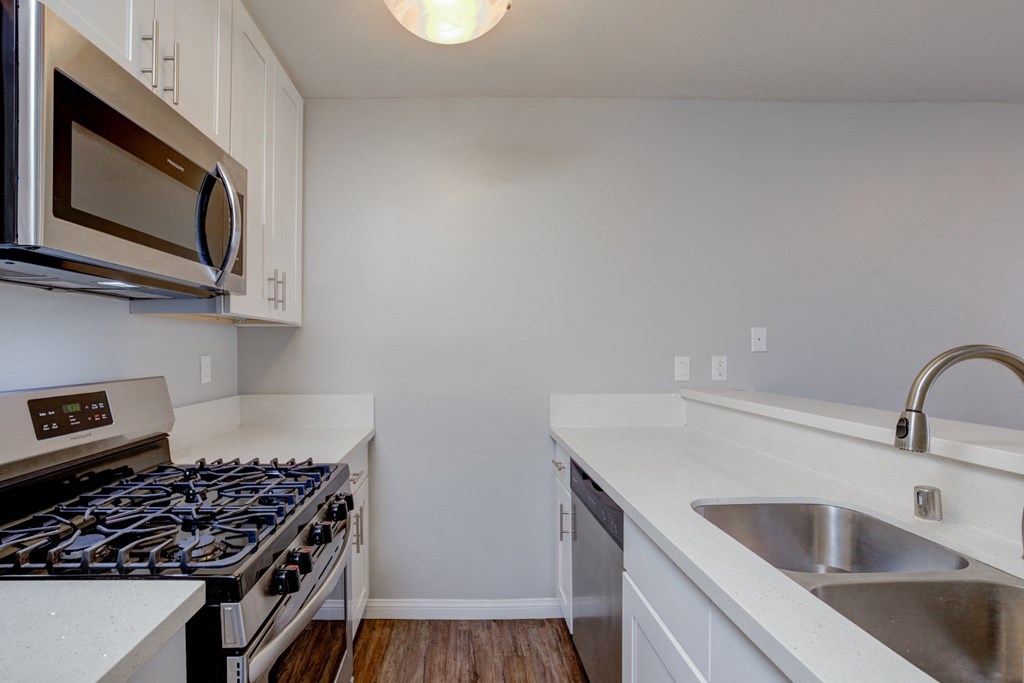 an empty kitchen with a stove and a sink