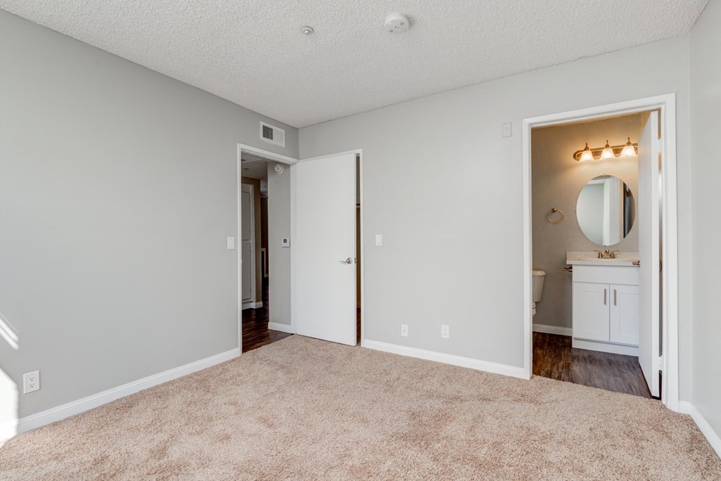 an empty living room with a bathroom and a closet