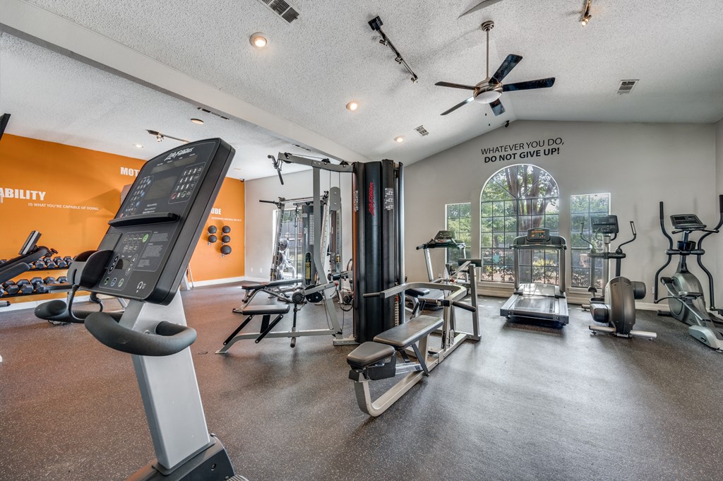 spacious gym with cardio machines and weights at the everyday gardener apartments