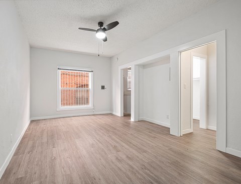 A room with a ceiling fan and a window with orange blinds at Hillstone Flats Apartments, Los Angeles, CA