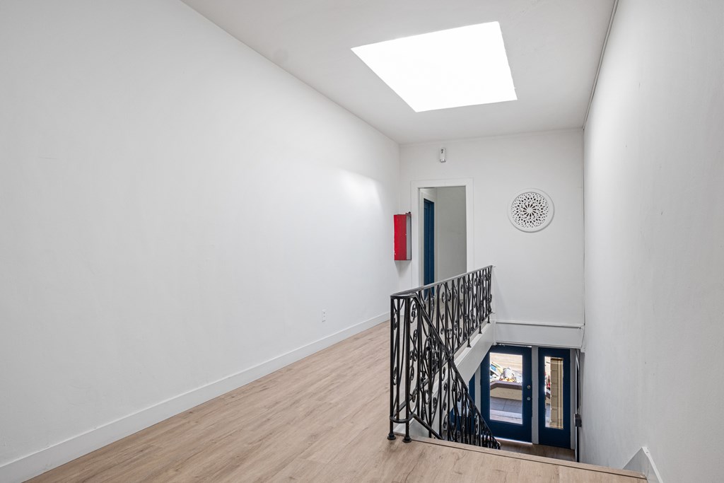 A white room with a skylight and a black metal staircase at Hillstone Flats Apartments, Los Angeles, CA