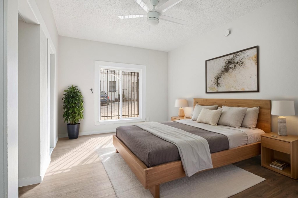 A bedroom with a large bed and a ceiling fan at Hillstone Flats Apartments, Los Angeles, CA