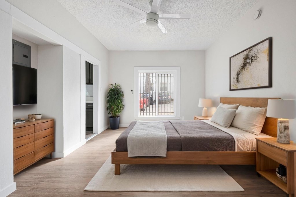 A bedroom with a bed, nightstand, and a ceiling fan at Hillstone Flats Apartments, Los Angeles, CA