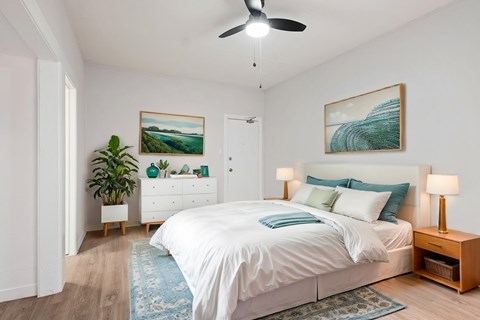 A bedroom with a large bed and a painting on the wall at Hillstone Flats Apartments, Los Angeles, CA