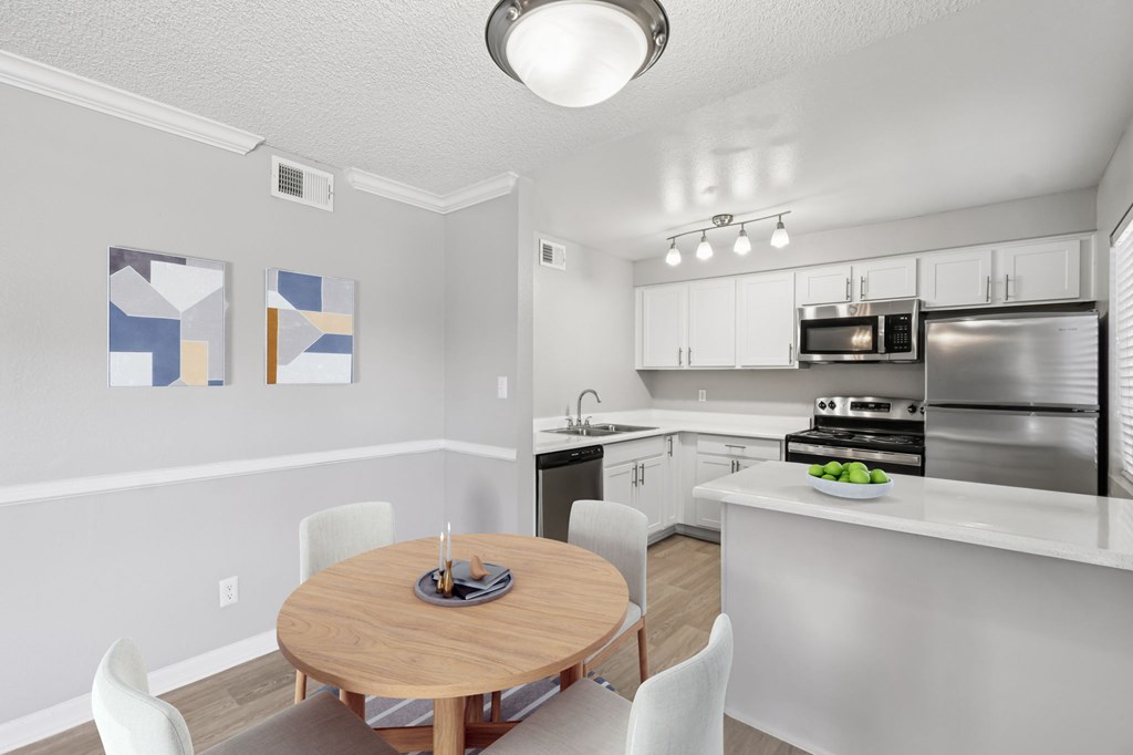 A kitchen with a table and chairs in the middle of the room.