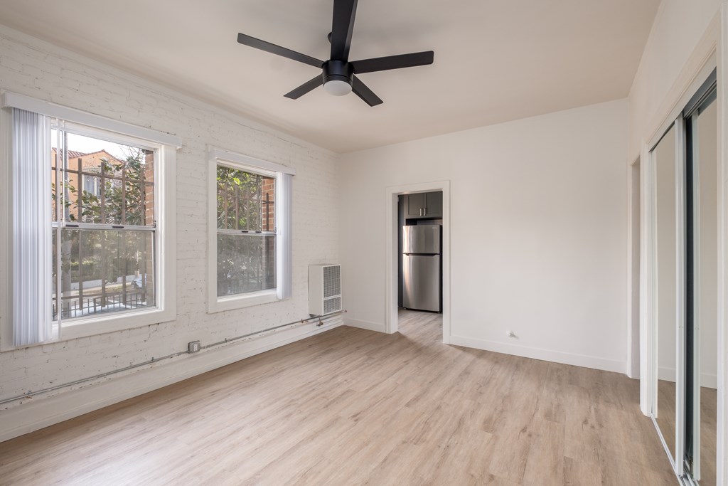 A room with a ceiling fan and a refrigerator at Kenmore Park Apartments, Los Angeles, 90004