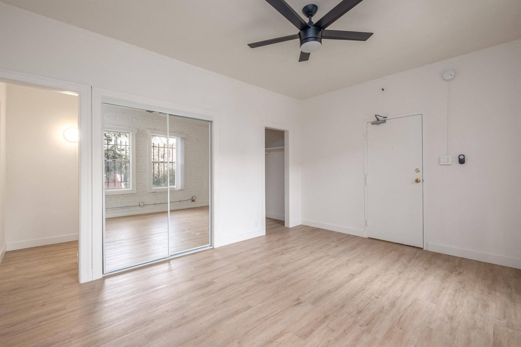 A room with a ceiling fan and wooden flooring at Kenmore Park Apartments, Los Angeles, CA