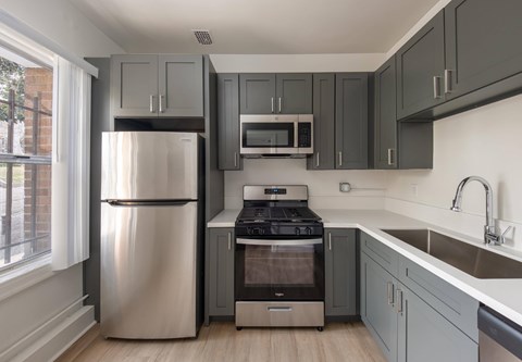 A modern kitchen with a stainless steel refrigerator and a built-in oven.
